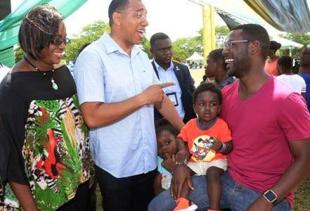 Prime Minister Andrew Holness (centre) and his wife Juliet speaking with Noah Moulton, while his son Andre Moulton, sits on his lap at the Father's Day picnic held at the Office of the Prime Minister yesterday. (Photo: Joseph Wellington) 