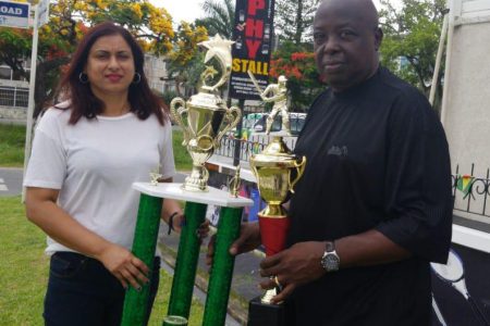 President of the Georgetown Softball Cricket League Inc., Ian John (right) and Devi Sunich of Trophy Stall pose with some of the trophies for tomorrow’s tournament.
