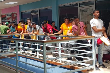 Venezuelan migrants wait in line to register at the Caroline Building, Wilson Road, Scarborough, Tobago, on Saturday.