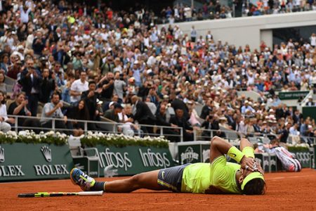BACK ON TRACK! Rafael Nadal lies flat on his back after winning a record 12th French Open title yesterday.
