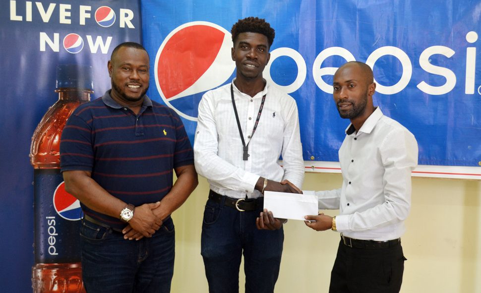 Pepsi Brand Manager Larry Wills [right] making the presentation to Petra Organization representative Mark Alleyne [centre] while Petra Director Troy Mendonca looks on.
