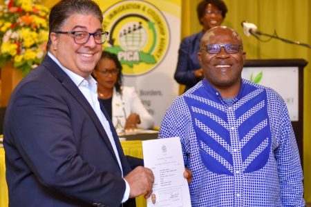 Passport, Immigration and Citizenship Agency (PICA) Advisory Board Chairman, Joseph Issa (left), presents Jerry Bayeshea with his citizenship certificate. The presentation was made during PICA's fourth citizenship swearing-in ceremony at The Knutsford Court Hotel in New Kingston, on Thursday (June 27).