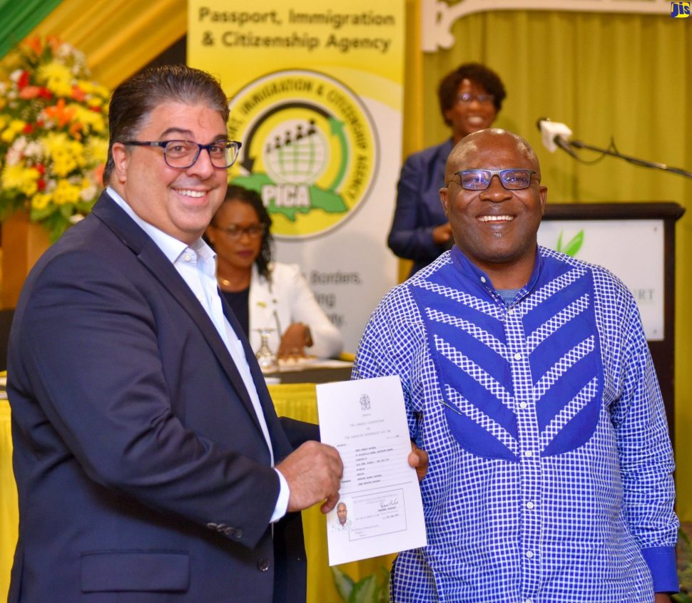 Passport, Immigration and Citizenship Agency (PICA) Advisory Board Chairman, Joseph Issa (left), presents Jerry Bayeshea with his citizenship certificate. The presentation was made during PICA's fourth citizenship swearing-in ceremony at The Knutsford Court Hotel in New Kingston, on Thursday (June 27).