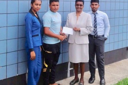 Branch Manager of the RHT Republic Bank Doodmatee Bhollaram hands over the donation to RHTYSC assistant secretary Simon Naidu in the presence of two staff members of the bank.
