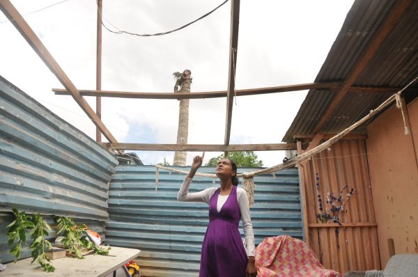 Reshma Katwaroo, shows the living room section of her home where the roof was blown off by a National Security helicopter yesterday.