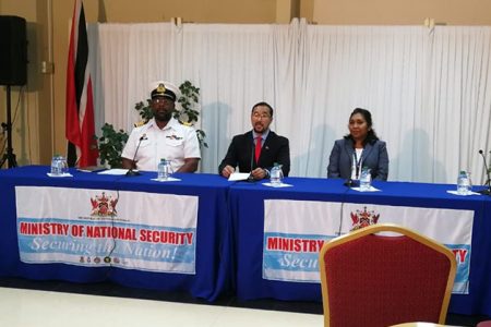 National Security Minister Stuart Young (centre) addresses the media at the close of registration yesterday.