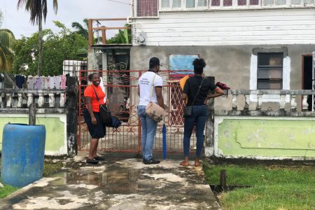 GECOM staff entering a resident’s yard at Anna Catherina, West Bank Demerara, to conduct registration
