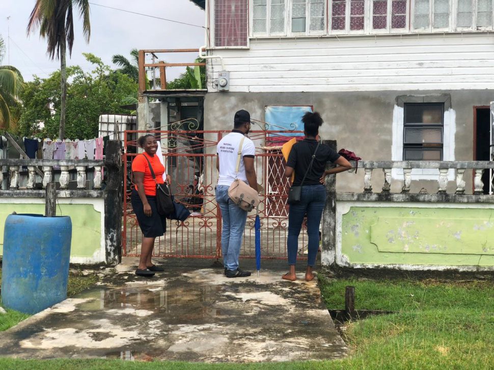 GECOM staff entering a resident’s yard at Anna Catherina, West Bank Demerara, to conduct registration
