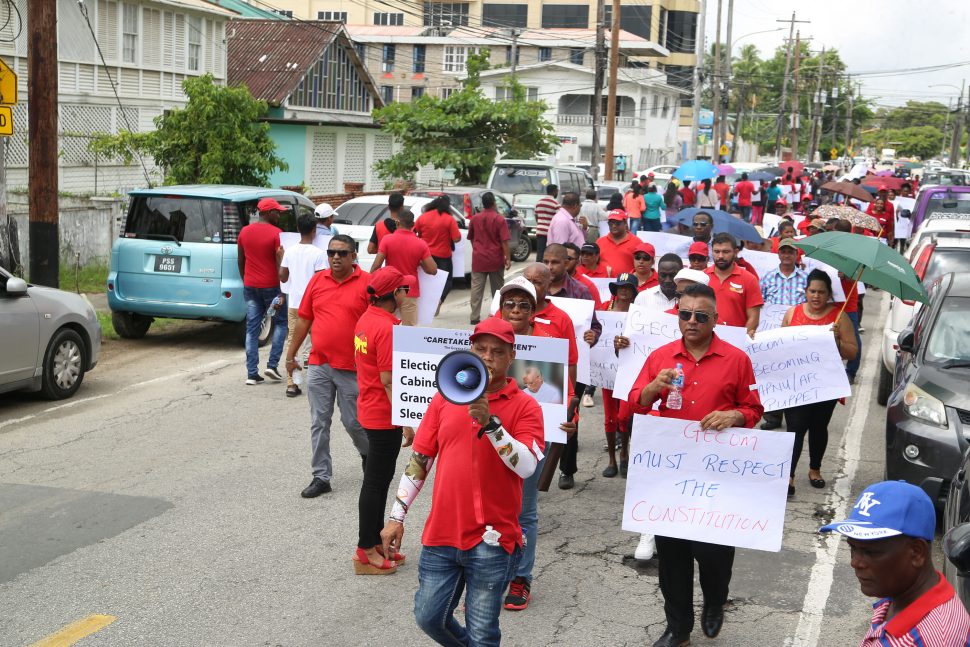 Some of the PPP’s supporters protesting yesterday in Kingston, near the GECOM headquarters. They called once more for the holding of general elections and also urged against the holding of a national house-to-house registration exercise. See story on page 11. [Photo by Terrence Thompson)