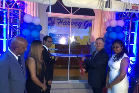 CEO of Harvey Gulf, Shane Guidry (second, from right) is assisted by head of the American Chambers of Commerce (AMCHAM) Zulfikar Ally (third, from left) as he cuts the ribbon to officially open the local office on Wednesday night.
