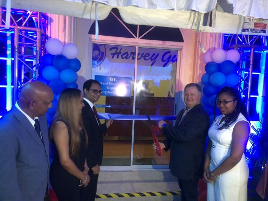 CEO of Harvey Gulf, Shane Guidry (second, from right) is assisted by head of the American Chambers of Commerce (AMCHAM) Zulfikar Ally (third, from left) as he cuts the ribbon to officially open the local office on Wednesday night.
