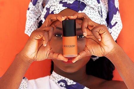 Designer Deborah Kehinde holds up one of her beauty products.