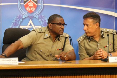 Crime and Problem Analysis branch head acting ASP Michael Pierre, left, chats with Commissioner of Police Gary Griffith during the police briefing at the Police Administration Building, Sackville Street, Port-of-Spain, on Wednesday.