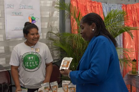 Dawn Daw from Orealla (left)  promoting her pineapple fruit snack to Minister within the Ministry of Agriculture, with responsibility for Rural Affairs, Valerie Adams-Yearwood. (DPI photo)