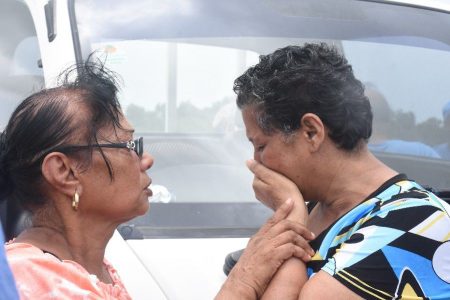 Kalawatee Jagessar right mother of missing fisherman Anand Rampersad sobs at the Orange Valley ,Couva fishing depot yesterday. Photo:TREVOR WATSON