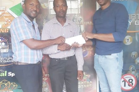 Real Sports Entertainment Group co-director Challus McKinnon (left) collecting a sponsorship cheque from a SuperBet Guyana representative in the presence of fellow co-director Joel Gibson (centre).
