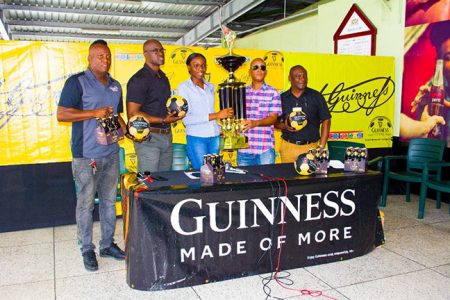 Tournament coordinator and Director of Three Peat Promotions Rawle Welch [centre] receives  the championship trophy from Colours Representative Creana Damon in the presence of Guinness Brand Executive Lee Baptiste [2nd from left], Referees Coordinator Wayne Griffith [left] and Banks DIH Communications Manager Troy Peters.

