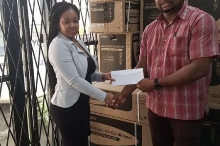 Accountant at Antarctic Maintenance and Repairs of 110 Third Street, Alberttown, Sade Barton (left) hands over the sponsorship cheque to founder of Jefford Track and Field Classic X, Edison Jefford yesterday.
