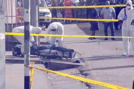 At the scene: Undertakers remove the body of Kyrel Braxton (also inset) who was killed at Cacique Street, Princes Town, yesterday. —Photo: TREVOR WATSON
