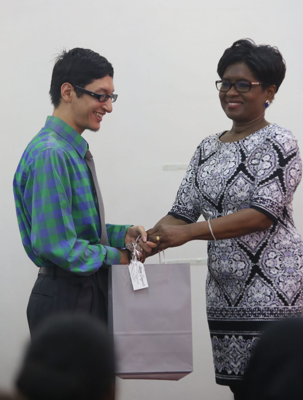 A representative of Republic Bank (right) presenting Scott Ting-A-Kee with the first prize for the Open Poetry Category. (Terrence Thompson photo) 