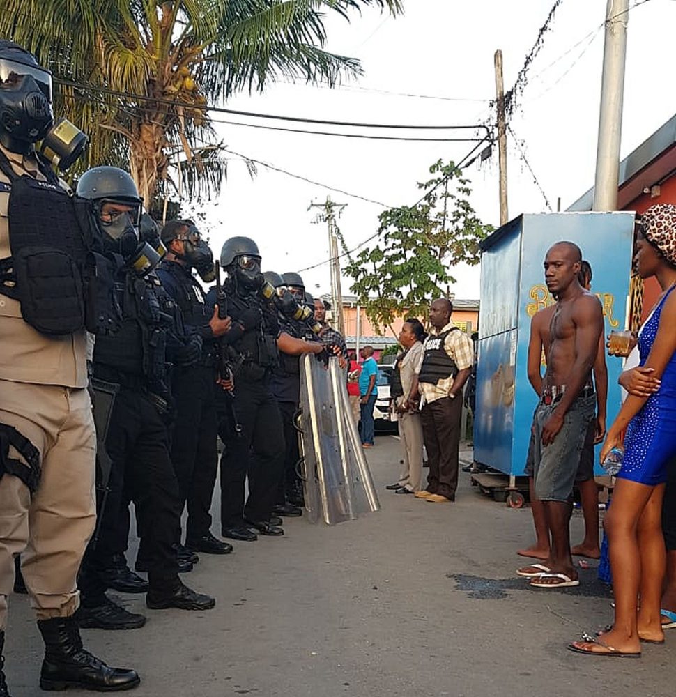 Sea Lots residents react to police officers following the shooting death of Akini Dole Adams yesterday.
