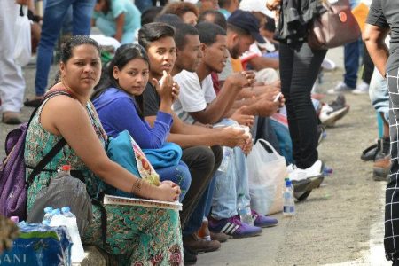 Venezuelans wait to register in Government’s amnesty programme outside the Queen’s Park Oval in Port of Spain on Friday. —Photo: Jermaine Cruickshank