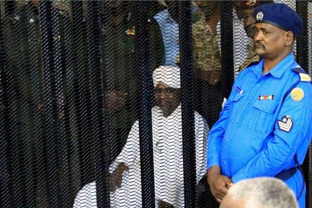 Sudan’s former president Omar Hassan al-Bashir sits guarded inside a cage at the courthouse, where he is facing corruption charges in Khartoum, Sudan yesterday. (REUTERS/Mohamed Nureldin Abdallah)
