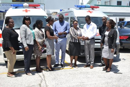 Minister of Public Health Volda Lawrence (fourth, from right) hands over the keys to the ambulance to Region Four’s RHO Dr Quincy Jones, while Director of Primary Healthcare Services Dr Ertenesia Hamilton (fourth, from left) hands over the keys to the ambulance to Region Three’s RHO Dr Cerdel McWatt. (DPI photo)