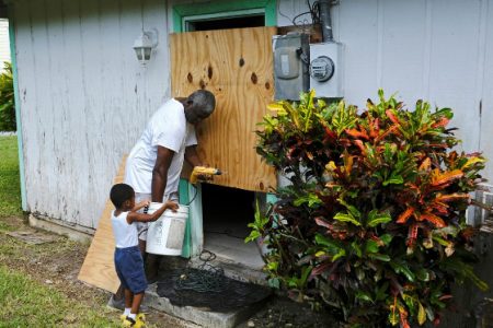 A small boy helps his father secure a door before the arrival of Hurricane Dorian on the Great Abaco island town of Marsh Harbour, Bahamas yesterday. (Reuters/Dante Carrer) 