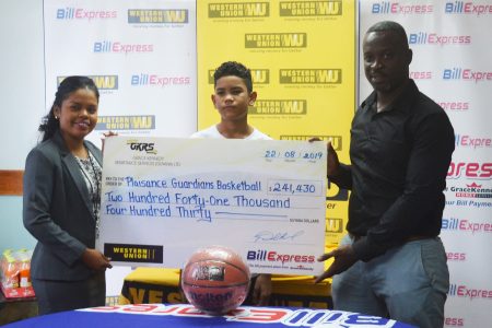 Junior Hercules (right), head of the HBA, collecting the sponsorship cheque from GraceKennedy Marketing Assistant Tina Gibson (left) in the presence of the camp participant Marion Fiedtkou.