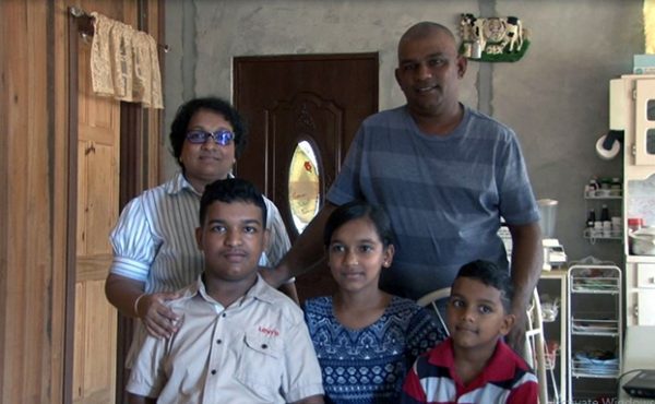 Davindra Bridgmohan (at left) with his mother, Indira, father, Yoganand, and two younger siblings in their newly-built home. The home was specially designed to cater to Davindra’s needs. 