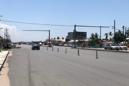 A section of the four-lane highway at Lusignan showing the installed traffic light supports at the intersection along with the newly paved and widened road.
