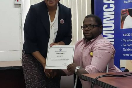 Minister of Public Telecommunications Catherine Hughes presenting web developer Jaime Skeete with his certificate.