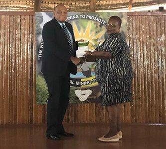 Minister of Natural Resources Raphael Trotman handing over the constitution to the President of the National Mining Syndicate, Cheryl Williams, yesterday. 