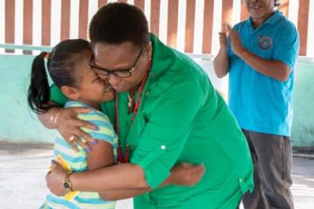 Minister of Public Health Volda Lawrence greets a child from the community (DPI photo)