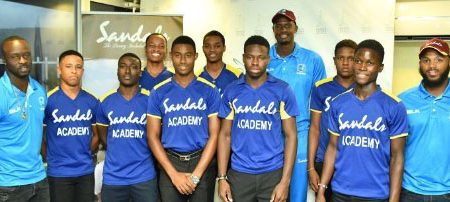 Seamer Kemar Roach (left), John Campbell (right) and captain Jason Holder (second from right -back row) pose with members of the Sandals Cricket Academy. (Photo courtesy CWI Media) 