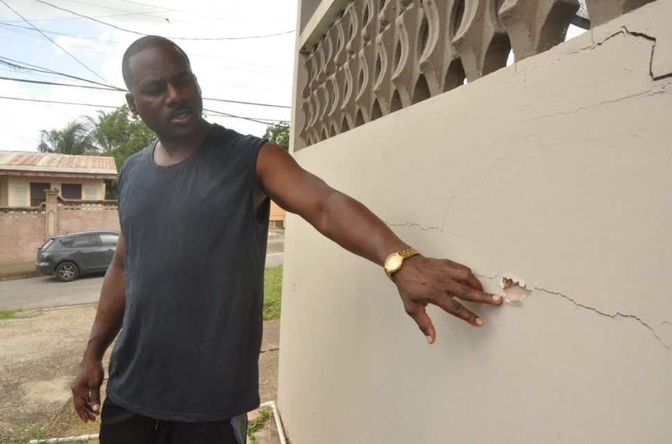  Prison Officer II Olang Harris points to a bullet hole at his Pleasantville home which was shot at early Sunday morning. (Trinidad Guardian photo)
