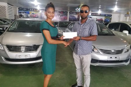 Afi Mohamed of B.M Soat Auto Sales, presents the company’s sponsorship pact to Rovin DeSouza, a representative of Jumbo Jet Thoroughbred Racing Committee (JJTRC).
