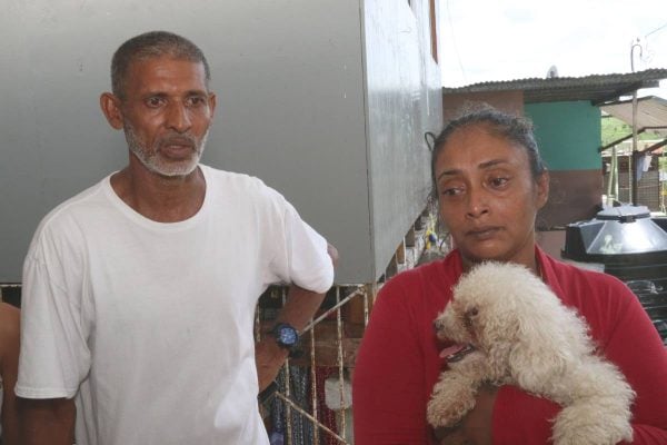 In-laws of Jessi Jacob in grief. From left is Isreal Jugoon (father-in-law), Sunita Sankar (mother-in-law ) and Mama his pet dog at the St Madeleine Home. PHOTO BY: MARVIN HAMILTON