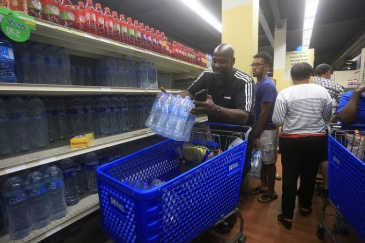 A man buys bottled water in preparation for the arrival of Tropical Storm Dorian at a supermarket in Gros Islet, St. Lucia August 26, 2019. REUTERS/Andrea de Silva