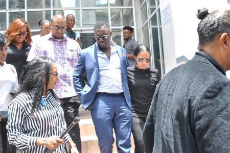 PSA President Watson Duke leaves the Port of Spain Magistrate’s Court in his wife's arms yesterday after appairing on sedition charges.