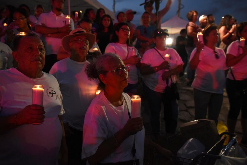 A group of people hold candles during a vigil at a memorial four days after a mass shooting at a Walmart store in El Paso, Texas, U.S. August 7, 2019. REUTERS/Callaghan O’Hare
