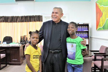 Minister George Norton shares a light photo moment with Emmanuella (right) and her cousin Success.