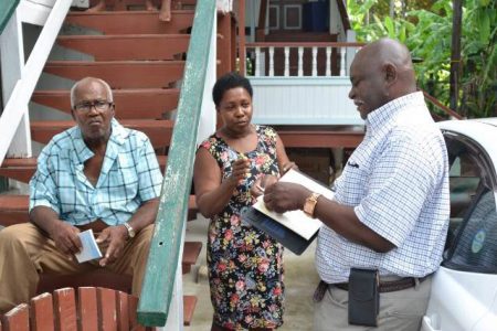 Minister of Citizenship, Winston Felix (right) speaking with residents yesterday (DPI photo)