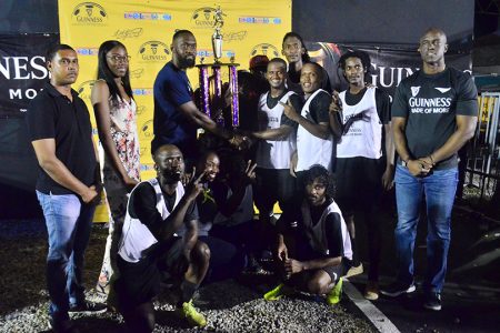 Gold is Money captain Hubert Pedro receiving the championship trophy from Director of Sports Christopher Jones in the presence of teammates and Guinness Brand Manager Lee Baptiste.