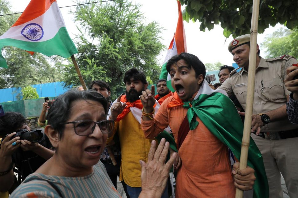 A woman, who was protesting against the scrapping of special constitutional status for Kashmir, argues with people who were celebrating the removal of the special status, during a gathering in New Delhi, India, August 7, 2019. REUTERS/Anushree Fadnavis