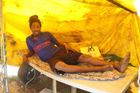 Jamal Young lies on a makeshift bed where he now lives under a tarpaulin with his wife in Couva.