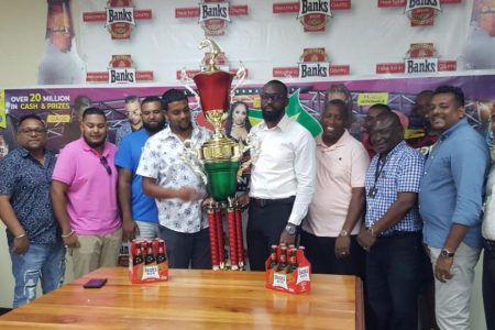 Nasrudeen Mohamed Jr. (center left) is presented with the Champion’s Trophy from Director of Sport Christopher Jones, during Bank DIH’s presentation on Friday.
