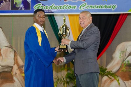 Minister of Social Cohesion, Dr. George Norton (right) presents a trophy to Best Graduating Student, Isaiah Knights at the National Cultural Centre. (DPI photo)
