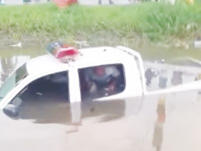 A Guyana Police Force pick-up ended up in trench near the Square of the Revolution yesterday morning after the driver reportedly lost control of the vehicle during a chase. At the time, three ranks, including the driver, were in the vehicle. In photo, one of the ranks is seen trying to make his way out of the backseat. No injuries were reported. 